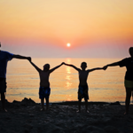 Familie im Sonnenuntergang am Strand